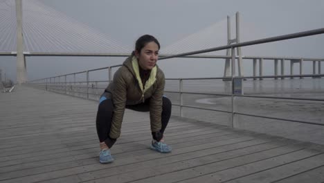 Concentrated-hindu-woman-exercising-on-wooden-pier